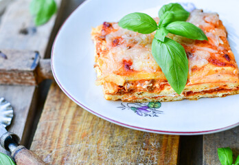   Delicious Home made keto diet  Lasagna bolognese  with  Lupin Flour, minced meat,tomato sauce and spinach  on a wooden rustic  background.Home made low carb italian meal