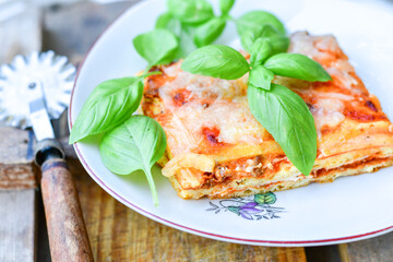   Delicious Home made keto diet  Lasagna bolognese  with  Lupin Flour, minced meat,tomato sauce and spinach  on a wooden rustic  background.Home made low carb italian meal