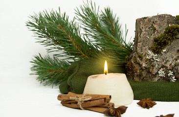 Fototapeta na wymiar New Year, Christmas candle with spruce branches and fragrant cinnamon.