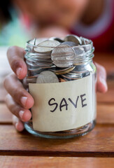 Savings deposit coins in a clear glass bottle.