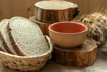 Template with slices of rye bread, ears of rye, cross sections of tree on burlap. Harvesting concept. Copy space.