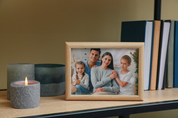 Framed family photo on wooden shelf indoors