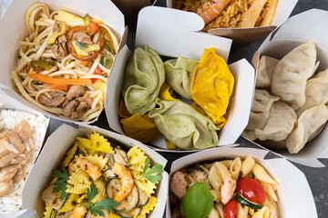 Food delivery. Different wok box with healthy food chinese dumplings jiaozi, noodles with chicken,...
