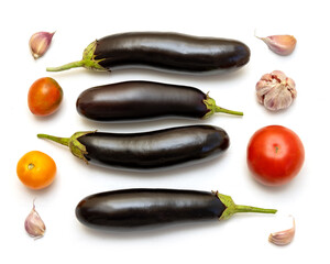 Eggplants, tomatoes, garlic on the table on a white background. Set about cooking a delicious...