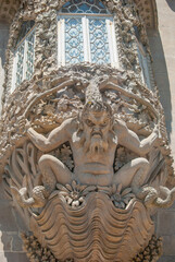 Decorative fierce merman gargoyle corbel guarding the entrance of Pena Palace, Sintra, Portugal -...