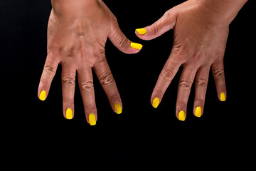 Hands with manicure isolated on black. Manicure service. Making nail arts.