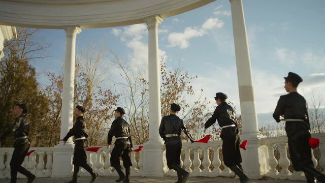 4K Group of Caucasian dancers in local black costumes perform traditional folk dance . Group of Men dancing traditional dance with handkerchief . Outdoor Shot on RED EPIC DRAGON Cinema Camera .