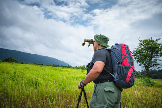 Tourists watching bird hornbill and monkey with binoculars in the tropical forest. Khao Yai National Park, Thailand. Bird, hornbill And Monkey watching tour. Image of the concept of eco-tourism.