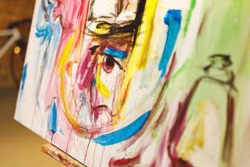 Fototapeta premium Close up of modern abstract oil painting on canvas sitting on easel in artists studio