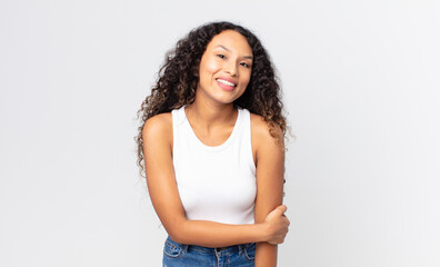 pretty hispanic woman laughing shyly and cheerfully, with a friendly and positive but insecure...