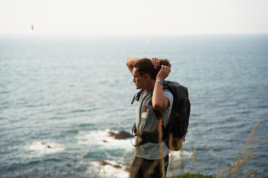 Traveling man walking on hill against sea