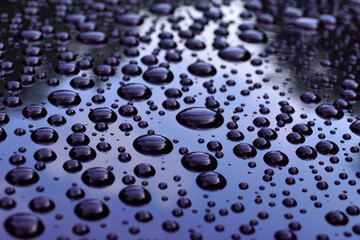 The surface of the washed car. Water droplets stay on its surface.