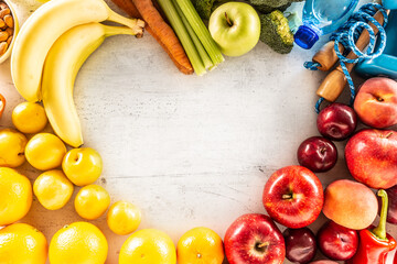 Heart shape made of organic vegetables fresh fruits and exercise tools. The concept of a healthy diet and exercise