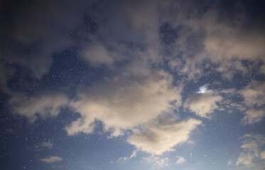 Starry sky and long exposhur clouds. Dark night sky with clouds. Astronomical background.
