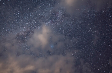 Starry sky and long exposhur clouds. Dark night sky with clouds. Astronomical background.