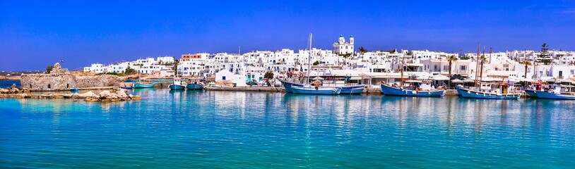 Fototapeta na wymiar Greece travel. Cyclades, Paros island. Charming fishing village Naousa. view of old port with boats and street taverns by the sea.