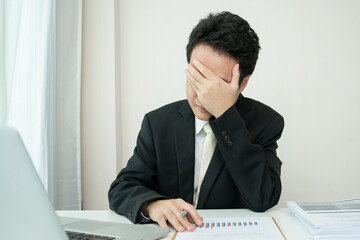 Unhappy Asian young businessman feels very upset and despair.