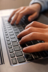 Hands typing on a laptop