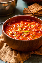 Matbucha - Moroccan Tomato dip. Sauce of tomato, pepper, garlic and chili pepper in a bowl on a dark background. Vegan food.