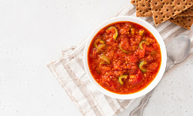 Matbucha - Moroccan Tomato dip. Sauce of tomato, pepper, garlic and chili pepper in a bowl on a white background. Vegan food.
