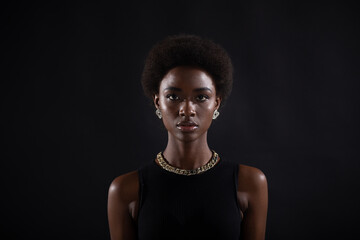 Portrait of young serious stylish black woman. Beautiful curly dark haired african american girl...
