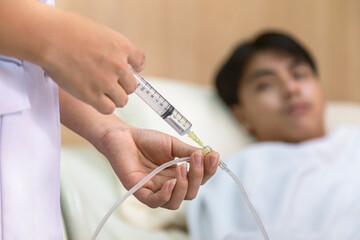 doctor or nurse giving medicine injection to iv tube for patient treatment at hospital. healthcare...