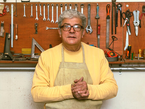 Hombre, herrero en su taller delante de sus herramientas de trabajo