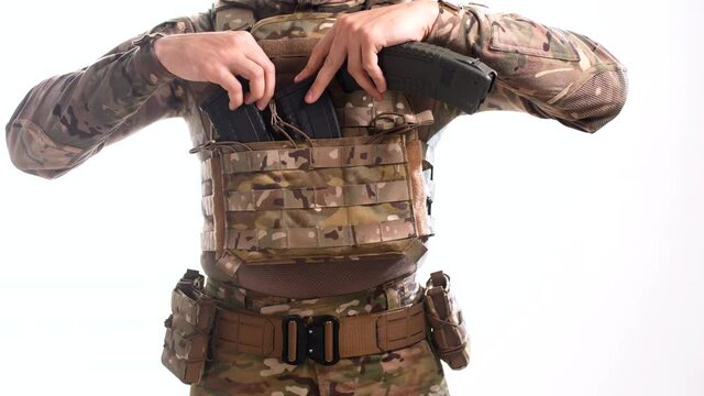 Man in body armor removes empty rifle magazines