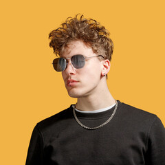 Fototapeta premium portrait of an epic man in sunglasses. studio photo yellow background