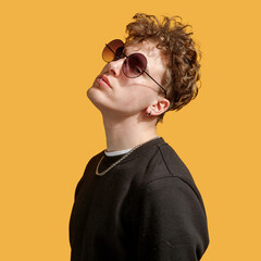 portrait of an epic man in sunglasses. studio photo yellow background