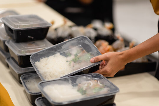 Hands Picking Up The Lunch Box That Is On The Table