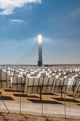 Concentrated solar power plant with mirrors focusing the sun energy at the steam turbine tower. - obrazy, fototapety, plakaty