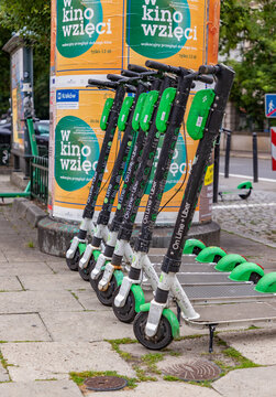 Krakow, Poland - July 22, 2021: A picture of a group of Lime electric scooters parked on the sidewalk.