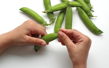 Fresh green peas in a pod and children's hands