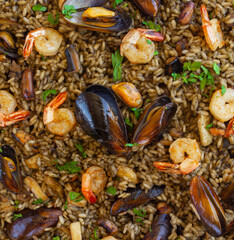 Close-up of a traditional spanish black paella with shrimps, mussels and squid ink. view from above, flat lay