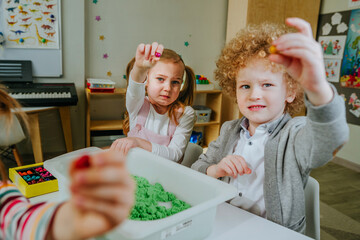 Preschool students playing with kinetic sand in kindergarten