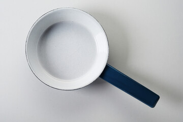Empty enameled metal frying pan