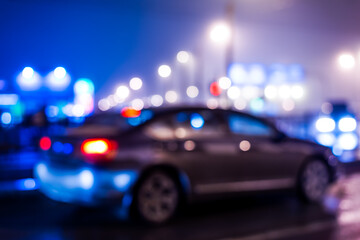 Fototapeta premium City night lights, car standing at the traffic lights. Defocused image