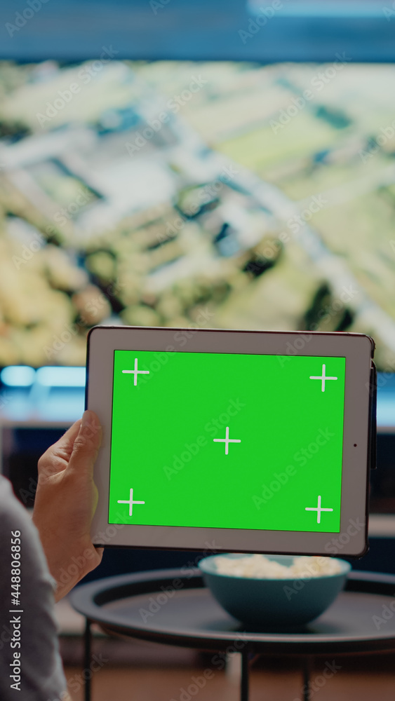 Poster person using modern tablet horizontally for green screen display in living room at home. user of chr