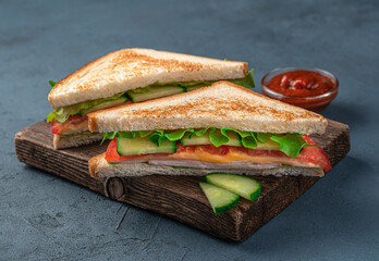 Club sandwiches with ham, cheese and vegetables on a dark blue background. Close-up. Fast food.