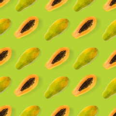 Fresh ripe papaya seamless pattern on green background. Tropical abstract background. Top view. Creative design, minimal flat lay concept. Trend tropical fruit food background pattern
