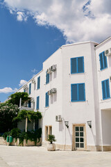 Fototapeta na wymiar Three-storey white apartment building with greenery around