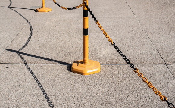 a post with a chain casting shadow to a floor