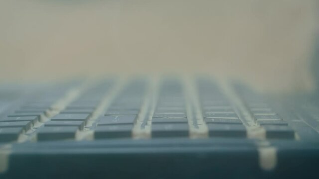 Keyboard of dustproof rugged laptop computer for military, outdoor and industrial use during dust resistance test - sand storm - close up view. Protective, resistant, safety, technology concept