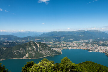 Fototapeta na wymiar Gorgeous view from the hill top at Balcony of Italy, over Lake Lugano, city Lugano and other cities. The view go far into Switzerland, all to the way to the Swiss alps. Shot from the Italian side of t