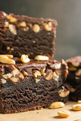 Brownie with nuts, brown chocolate cake in a close-up, texture cut, on a dark gray background