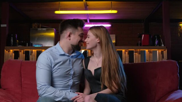 Couple kissing on a couch during a romantic date in a coffeeshop