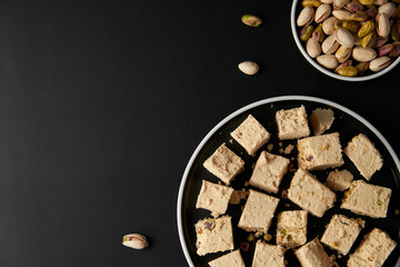 Organic halva with pistachios on black background. Traditional middle eastern sweets. Jewish,...