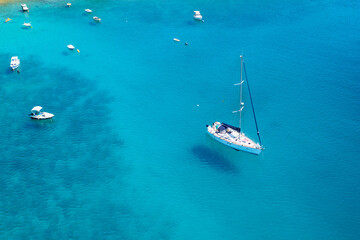 Aerial view of sailboat and small boats or yachts in the turquoise waters of the Adriatic sea