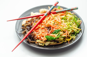 Cooked chicken breast pieces with egg noodles, carrots, and cabbage in a savory chow mein sauce